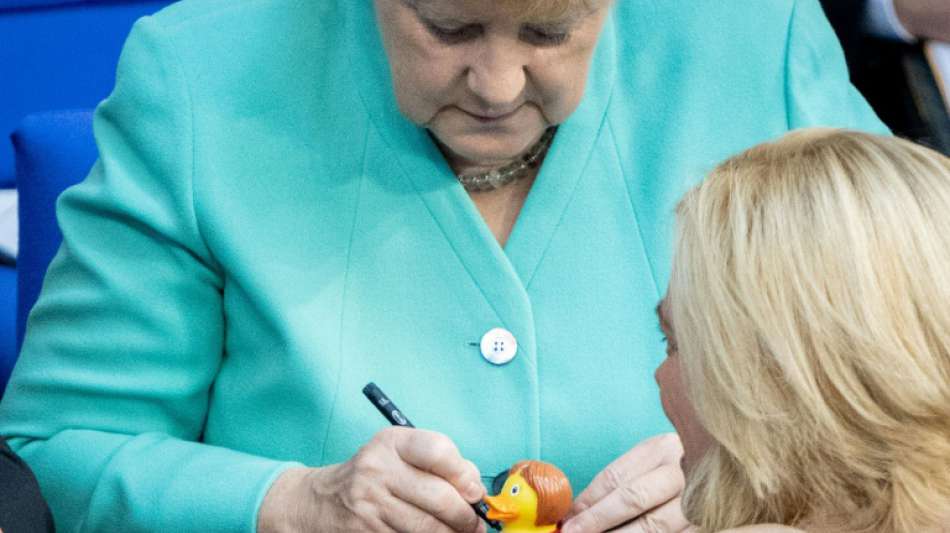 Merkel signiert im Bundestag "Badeente Angie" für Klöckner