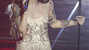 La Bambola di Pezza Cleo con la scritta 'Give Peace a chance' sull'abito