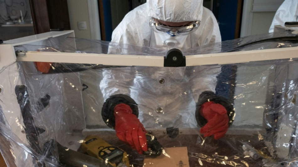 Au laboratoire de la pr&eacute;fecture de police, des experts avec la t&ecirc;te et les jambes